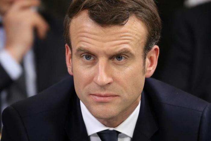 French president Emmanuel Macron (centre) takes part in a meeting in Evry-Courcouronnes, on February 4, 2019