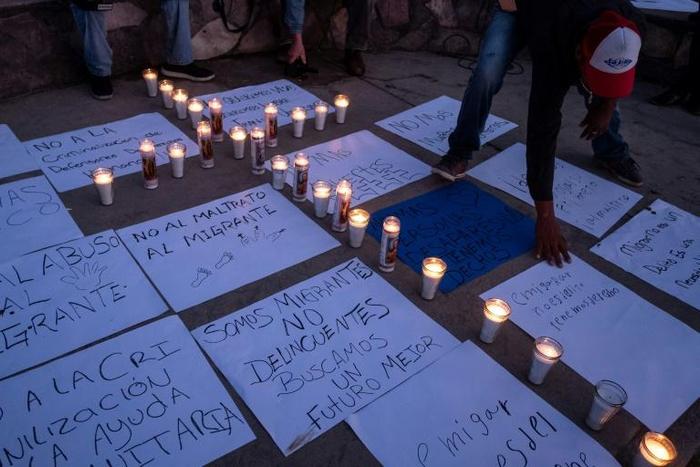 People hold a vigil for migrants who have died, have been detained and deported by US authorities, near the US-Mexico border fence in Playas de Tijuana, Mexico, on May 3, 2019