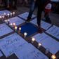 People hold a vigil for migrants who have died, have been detained and deported by US authorities, near the US-Mexico border fence in Playas de Tijuana, Mexico, on May 3, 2019