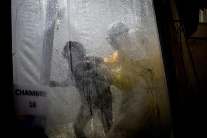Health workers help a woman into bed at an Ebola Treatment Centre in Butembo, Democratic Republic of Congo