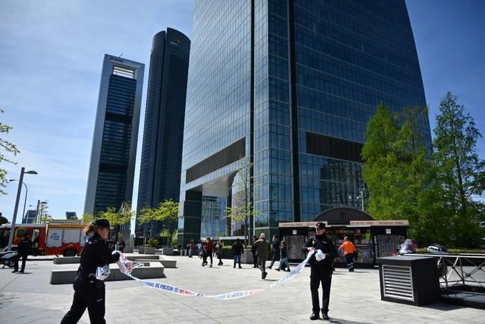Spanish police remove a cordon outside the Torrespacio skyscraper at the Cuatro Torres (Four Towers) business park in Madrid after a bomb warning proved to be false