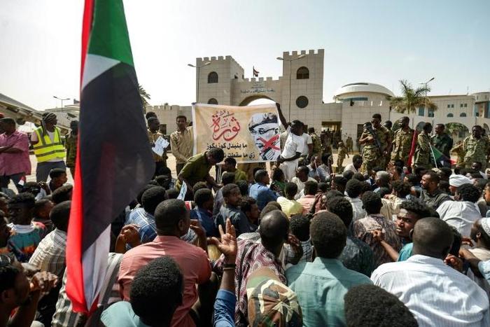 Protesters gather in front of soldiers during a rally demanding a civilian body to lead the transition to democracy, outside the army headquarters in the Sudanese capital Khartoum on April 12, 2019
