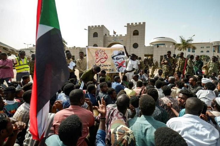 Protesters gather in front of soldiers during a rally demanding a civilian body to lead the transition to democracy, outside the army headquarters in the Sudanese capital Khartoum on April 12, 2019