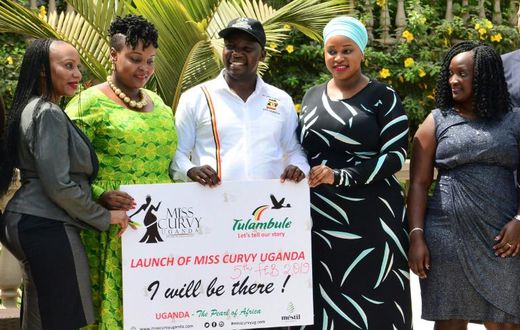 Uganda's Tourism Minister Godfrey Kiwanda posed with women during the launch of the Miss Curvy beauty contest in the capital Kampala