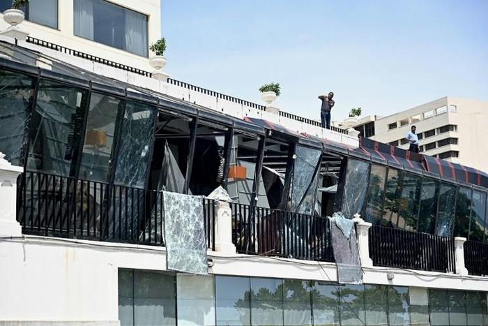 Two men inspect damage from the roof of a restaurant at the Kingsbury Hotel in Colombo on April 22, 2019, a day after it was hit during a series of bomb blasts targeting churches and luxury hotels in Sri Lanka