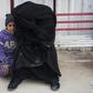 A Syrian woman and child wait at a camp for internally displaced people in al-Hol in northeastern Syria