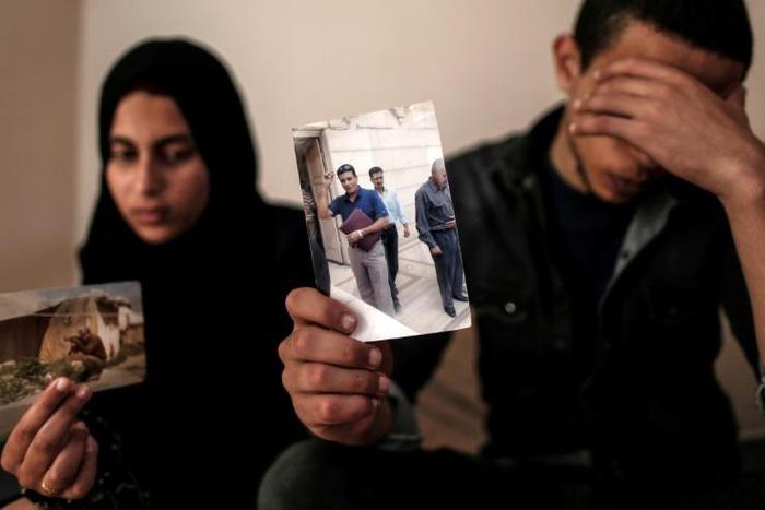 The daughter and son (pictured April 2019) of Zaki Mubarak, whose body was transferred to Cairo after Ankara said he had committed suicide in prison, hold his picture during an interview in their family home