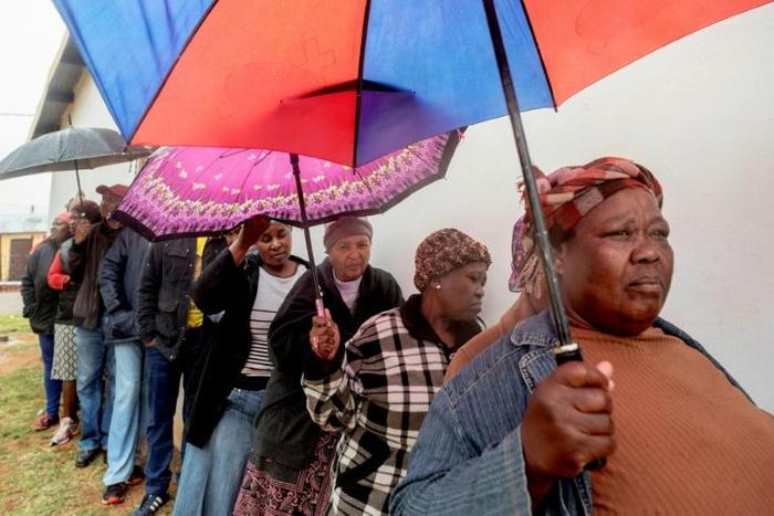 People queue to vote for South Africa's national and provincial elections at a polling station in the Tlhabologang township in Coligny