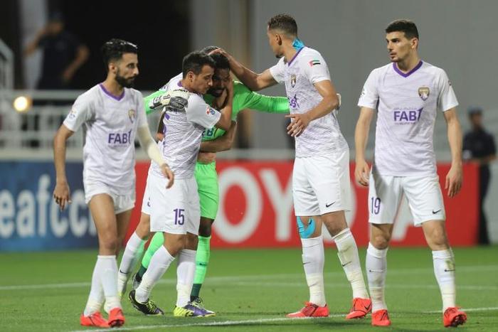 Al Ain players mob goalkeeper Khalid Eisa after his heroics allowed them to snatch a draw in Qatar