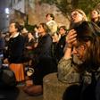 Onlookers react as they watch flames engulf Notre-Dame Cathedral in Paris on April 15, 2019
