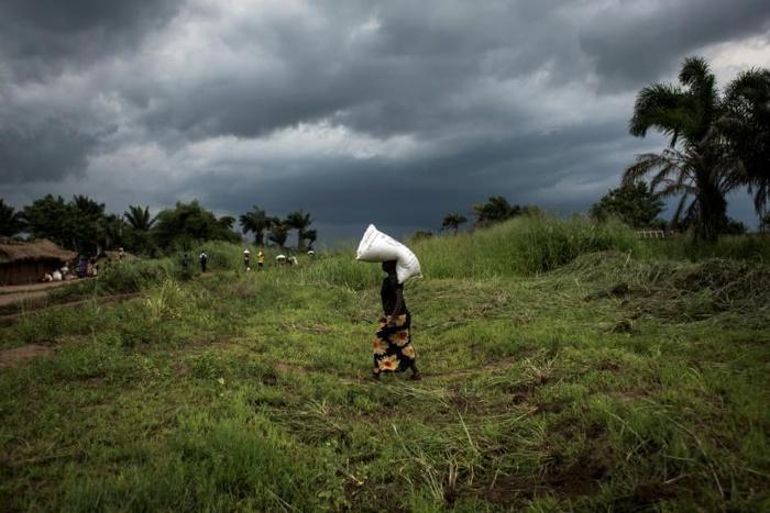 A Congolese woman carries a sack of food onto her heads at a food distribution on October 25, 2017 in Kasala, in the restive region of Kasai, central Democratic Republic of Congo