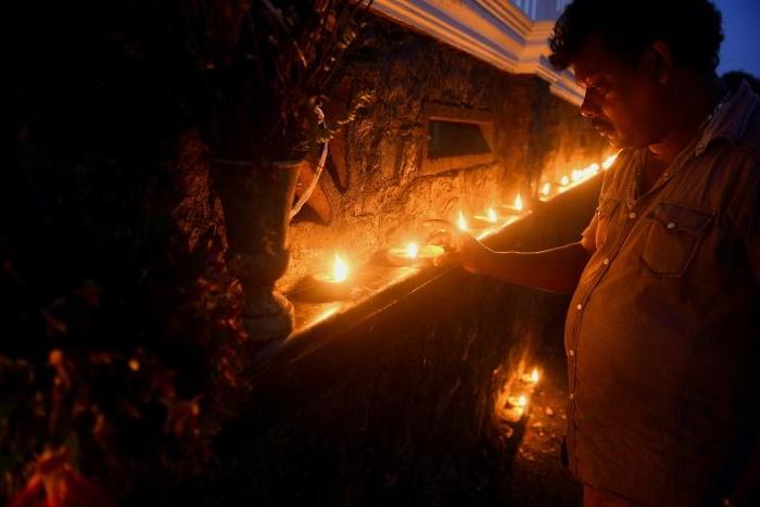 Local families come out every evening to light oil lamps and candles on the outside wall of St Sebastian's Church