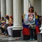 A supporter of Venezuelan President Nicolas Maduro holds a photo of his late predecessor Hugo Chavez at the National Assembly building in October 2017