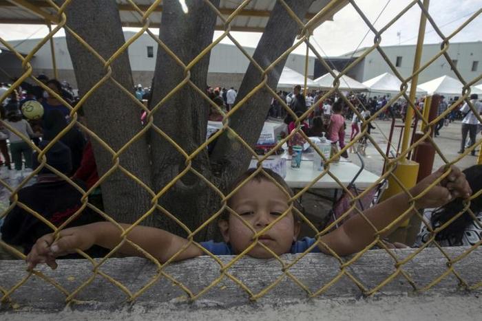 A Honduran boy, pictured in February 2018, looks through a fence from inside a shelter for migrants travelling to the United States in Piedras Negras, Mexico, on the US border