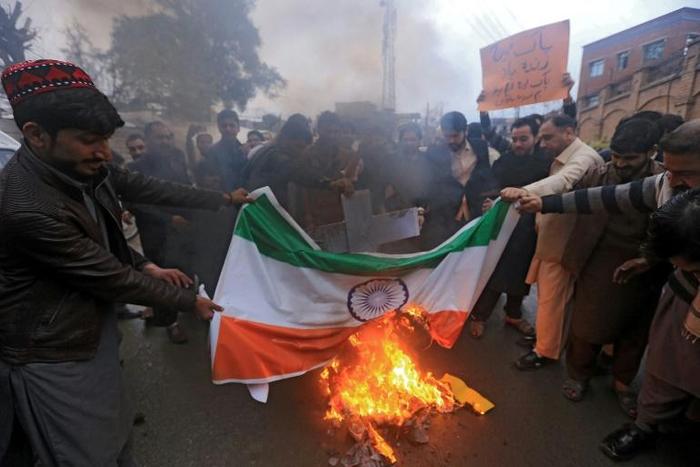 Pakistani protesters burn an Indian national flag during a protest in Peshawar on February 26, 2019, following the Indian Air Force (IAF) strike launched on a Jaish-e-Mohammad (JeM) camp at Balakot.