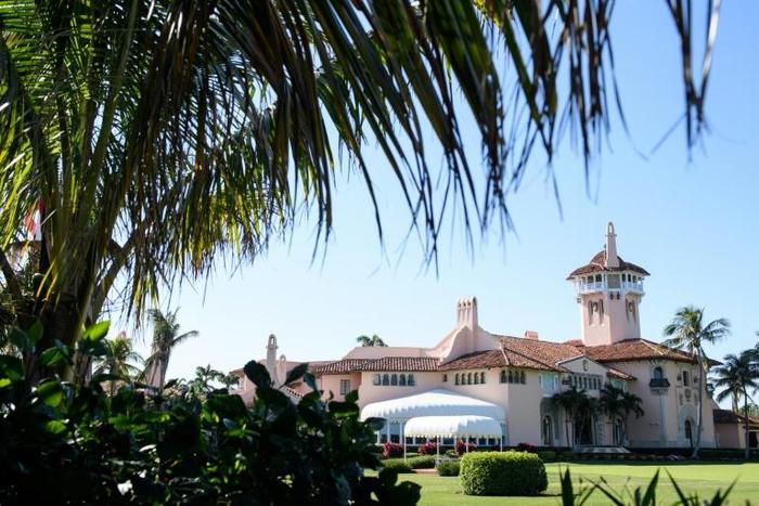The woman was arrested at Mar-a-Lago after attempting to enter while carrying multiple mobile phones and a thumb drive containing malware, according to court documents