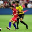 The USA's Cristian Roldan and Kevon Lambert of Jamaica battle for the ball in their friendly international