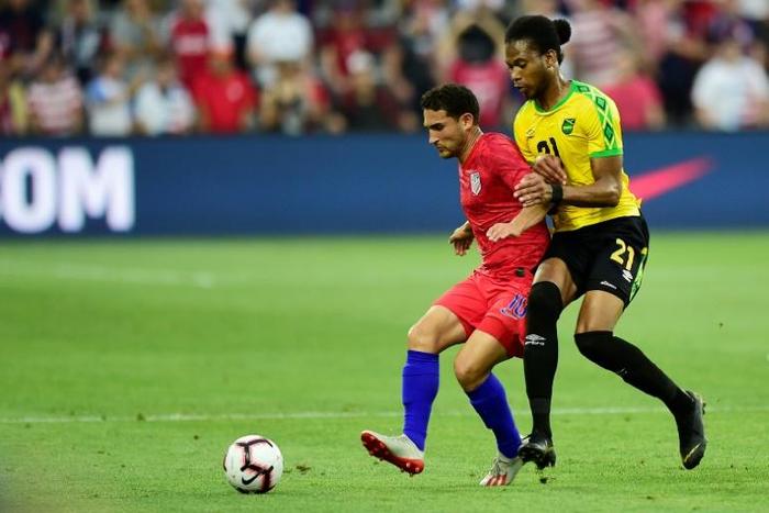 The USA's Cristian Roldan and Kevon Lambert of Jamaica battle for the ball in their friendly international