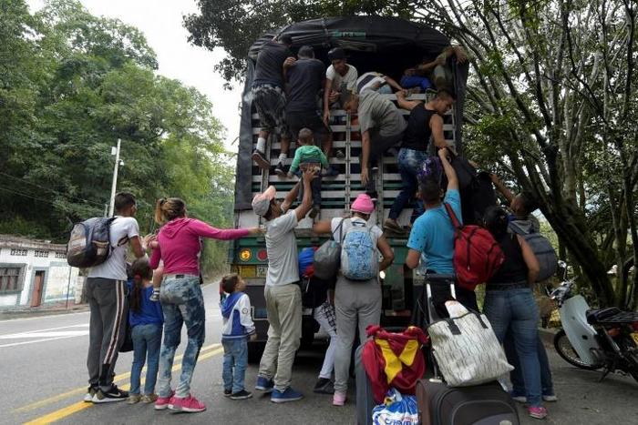 Venezuelan migrants (pictured February 2019) climb on a truck on the road from Cucuta to Pamplona in Colombia, which has received about a third of 3.7 million Venezuelan refugees