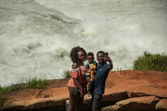 Big river: A family takes a selfie in front of the Nile during the Uganda National Kayaking Championships in Jinja in January. More than 250 people have died in selfie accidents around the world, according to a study published last year