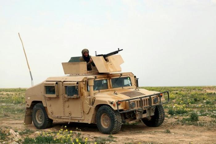 A fighter with the US-backed Syrian Democratic Forces (SDF) sits atop a military vehicle during an operation to expel Islamic State group (IS) jihadists from their last pocket, the Baghouz area in the eastern Syrian province of Deir Ezzor on February 1...