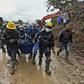 Firefighters carry away a dead body found under the mud in Rosas, southwest Colombia, following Sunday's mudslide provoked by heavy rains