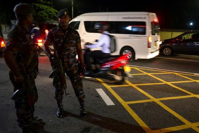 Sri Lankan security personnel stand guard at a checkpoint on a roadside in Colombo on May 13, 2019. A Muslim man was slashed to death in Sri Lanka, police said after imposing a nationwide curfew to contain a violent new backlash against Easter suicide ...