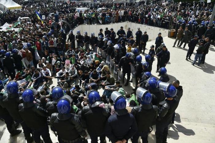 Algerian riot police monitor an anti-government protest in the capital Algiers