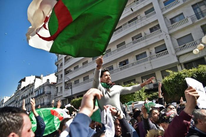Algerians wave the national flag during a protest rally against ailing President Bouteflika's bid for a fifth term, in the capital Algiers on March 1, 2019