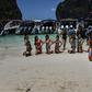 Tourists pose in Maya Bay before a row of boats in April 2018, shortly before the beach was ruled off-limits in a bid to protect the environment