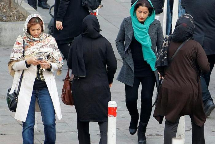 Iranian women wearing hijab walk down a street in the capital Tehran in this file picture taken on February 7, 2018