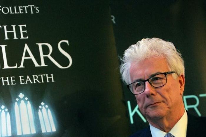 Ken Follett alongside an advertisement for his "The Pillars of the Earth" bestseller -- one of whose scenes is set in a Parisian cathedral that readers may very well assume is Notre-Dame