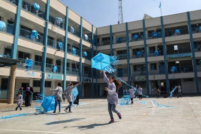 Palestinian girls fly kites in the courtyard of an UNRWA-run school in Gaza during a protest against US aid cuts that threatened their education until other donors stepped in