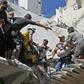 White Helmet rescuers and civilians extract a child from the rubble of a building destroyed during an air strike reportedly by Syrian regime forces and their allies on the town of Ariha, in Syria's Idlib province on May 27, 2019