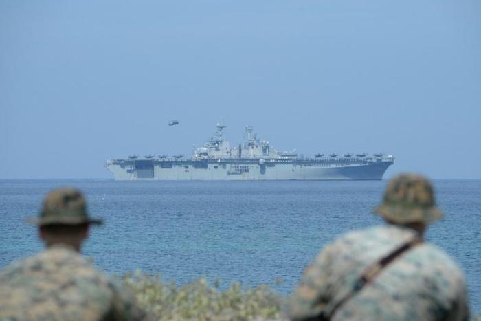 US Marines watch the US navy multipurpose amphibious assault ship 'USS Wasp' with F-35 lightning fighter jets on the deck during the annual joint US-Philippines military exercise on April 11, 2019