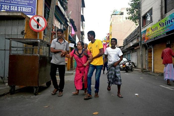 Colombo residents flee their home in fear of a car bomb near St. Anthony's Shrine in the wake of coordinated attacks