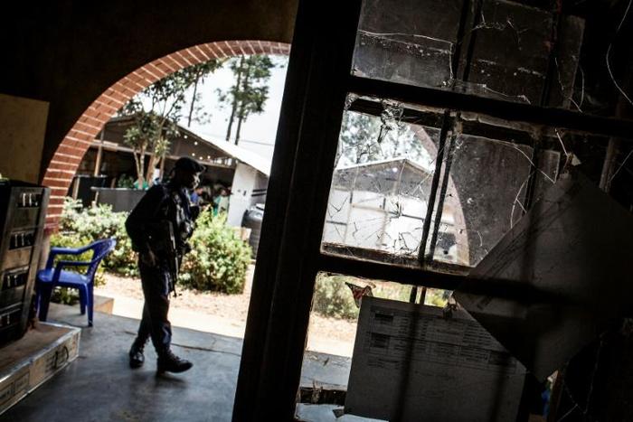 A police officer stands guard beside a window full of bullet holes at an Ebola treatment centre in Butembo. Suspected Mai-Mai tribal militia raided the ETC and killed a policeman and wounded a health worker early in March