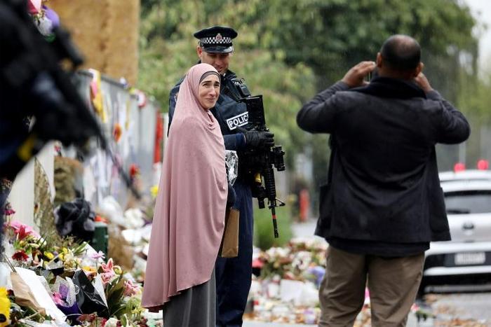Members of the Muslim community take pictures with armed police outside the Al Noor mosque in Christchurch