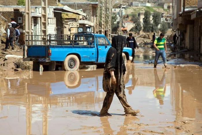 An Iranian woman walks through a flooded street in the city of Poldokhtar (pictured April 2, 2019) as the flood death toll reaches 70 people