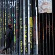 A man looks through the US-Mexico border fence in Playas de Tijuana, Baja California State, Mexico, on March 8, 2019