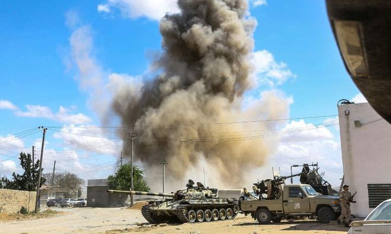 Smoke rises from an air strike behind a tank and pickup trucks of Libya's Government of National Accord during clashes in Wadi Rabie suburb south of the capital Tripoli.