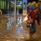 A Brazilian woman walks barefoot through floods in Rio de Janeiro -- in Sao Paulo, heavy rains triggered floods that left seven people dead