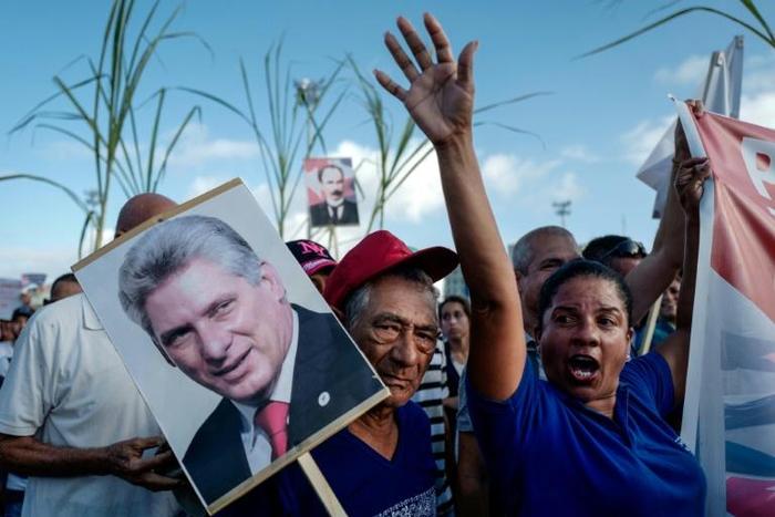 A woman holds a poster of Cuban president Miguel Diaz-Canel during the May Day rally in Havana's Revolution Square on May 1, 2019