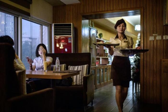 The Green Leaf Coffee Shop's 1970s-style decor is predominantly brown, and pictures of the Kimilsungia and Kimjongilia flowers named for North Korea's rulers are on show
