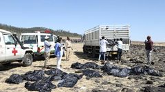 Rescue teams collect bodies at the crash site of an Ethiopia Airlines plane which came down near the capital Addis Ababa, killing all 157 on board