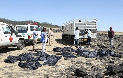 Rescue teams collect bodies at the crash site of an Ethiopia Airlines plane which came down near the capital Addis Ababa, killing all 157 on board