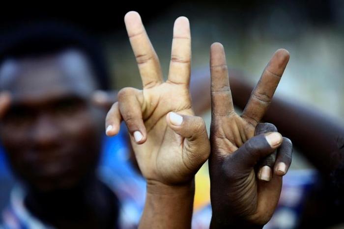 Sudanese demonstrators flash V-for-victory signs as they gather outside the military headquarters in Khartoum in the capital Khartoum on May 20, 2019