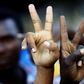 Sudanese demonstrators flash V-for-victory signs as they gather outside the military headquarters in Khartoum in the capital Khartoum on May 20, 2019