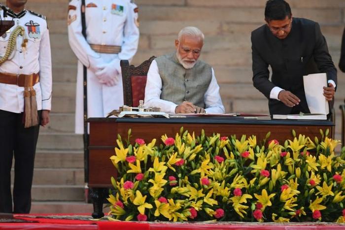 Indian Prime Minister Narendra Modi signs documents after taking the oath of office for a historic second term