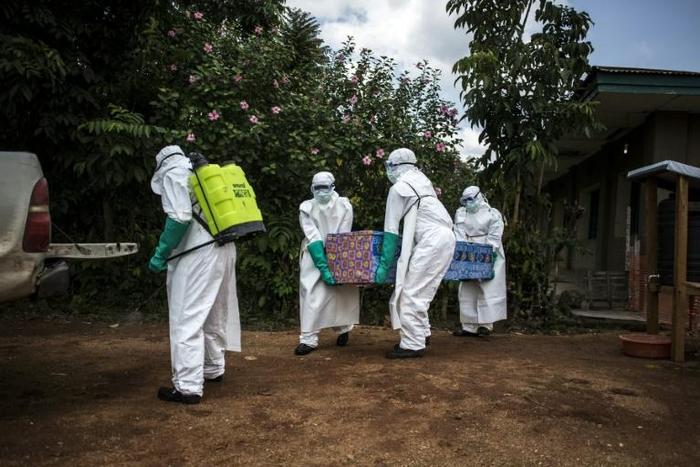 Health workers carry the coffin of an Ebola fatality in Mangina, North Kivu, last August